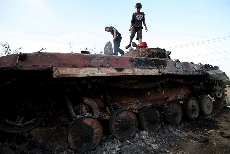 Jóvenes georgianos juegan sobre un tanque ruso quemado a unos 60 kilómetros de Tiflis, Georgia.