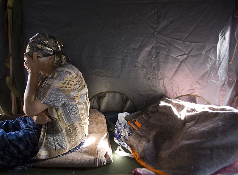 Una mujer junto a sus pertenencias en un campo de refugiados