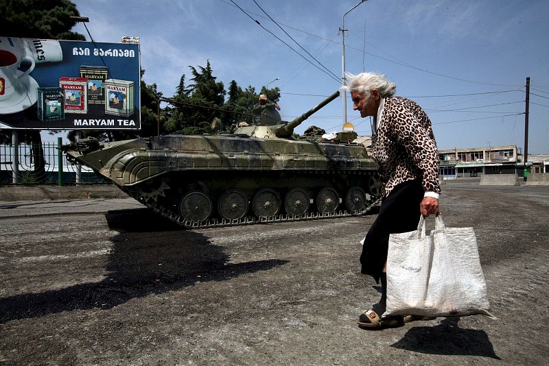 Una anciana pasa junto a un tanque ruso en Gori