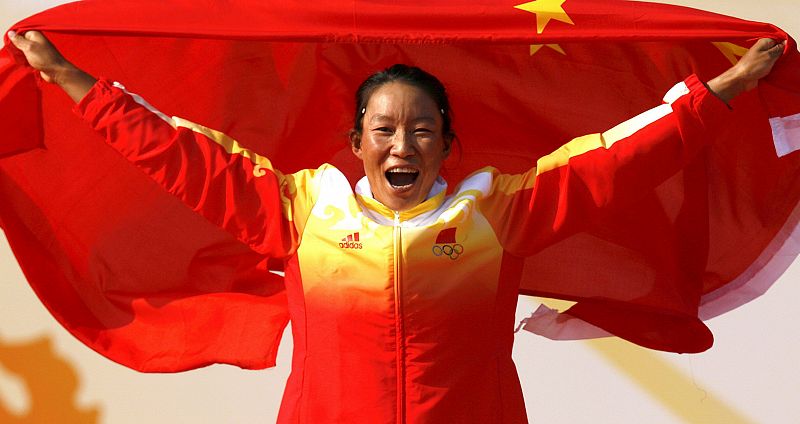 La deportista china Yin Jian celebra su medalla de oro en la competición de windsurf RS:X femenino.