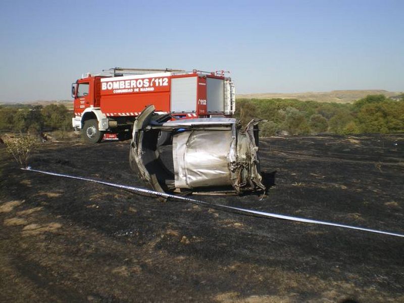 Restos del tren de aterrizaje frente a un camión de Bomberos