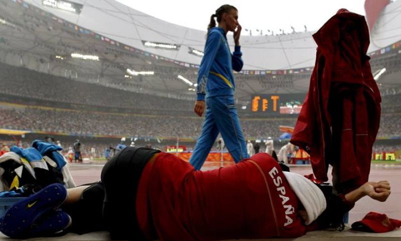La atleta española Ruth Beitia se toma un descanso mientras llueve antes de las clasificatorias de salto de altura femenino.