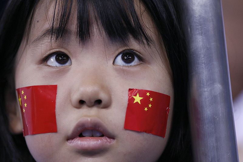 Una aficionada china anima durante los cuartos de final de la competición de tenis de mesa entre Wang Hao de China y Ko Lai Chak de Hong Kong.