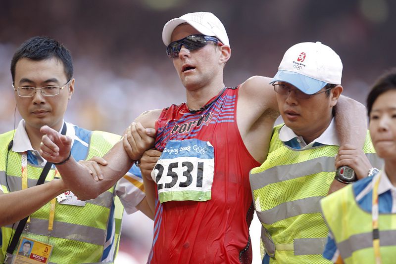 El noruego Erik Tysse es asistido por personal médico tras llegar a la línea final en la prueba de 50 kilómetros marcha masculina.