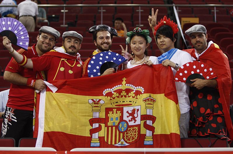 Aficionados españoles posan con ciudadanos chinos antes del inicio del partido de semifinales de baloncesto entre España y Lituania.