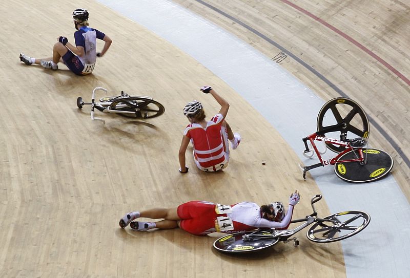 Sarah Hammer of the U.S., Trine Schmidt of Denmark and Satomi Wadami of Japan lay on the edge of the track after crashing during the women's track cycling points race at the Beijing 2008 Olympic Games