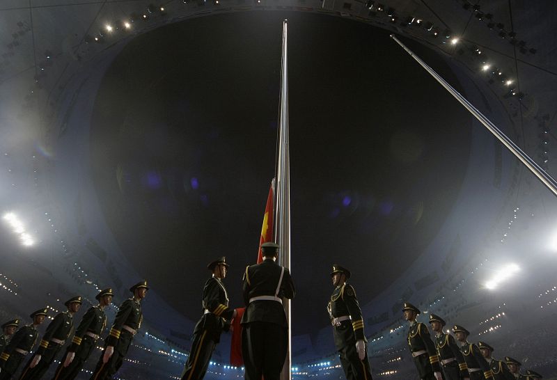 La policia paramilitar se prepara para izar la bandera china durante la cerenomia.