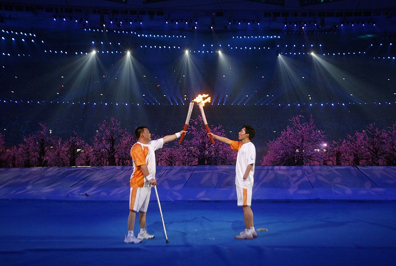 El ex atleta Wu Yunhu enciende con su compatriota Wang la antorcha de los Juegos Paralímpicos