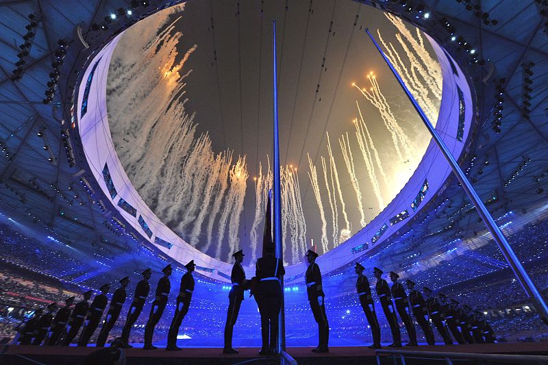 Soldados del Ejército de Liberación Popular chino se preparan para izar la bandera del país anfitrión.
