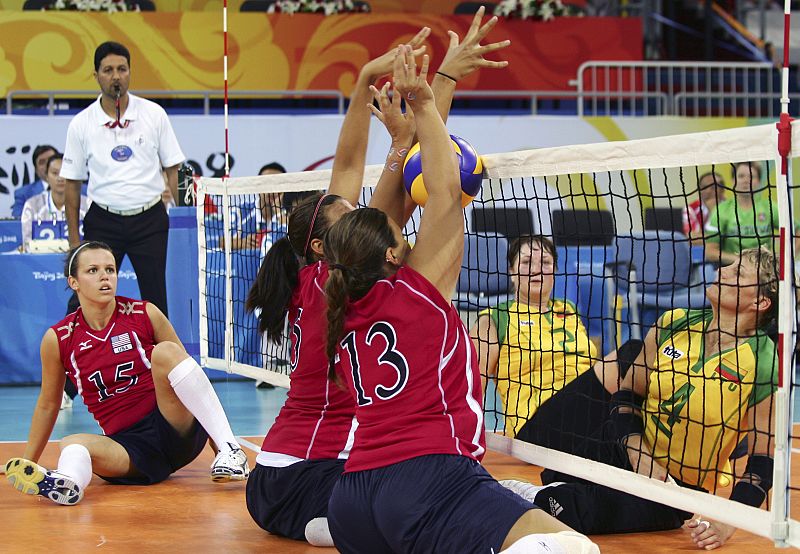 Nichole Millage y Katie Holloway de EE.UU. defienden ante Lituania durante el partido de voleybol en el grupo B.