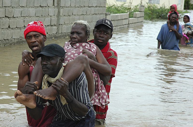 Un grupo de haitianos cruza un río en Puerto Príncipe
