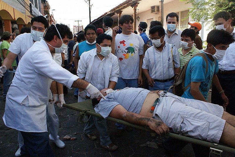 Un grupo de médicos sacan a un herido tras los enfrentamientos entre la policía y jovenes opositores al Gobierno de Morales.