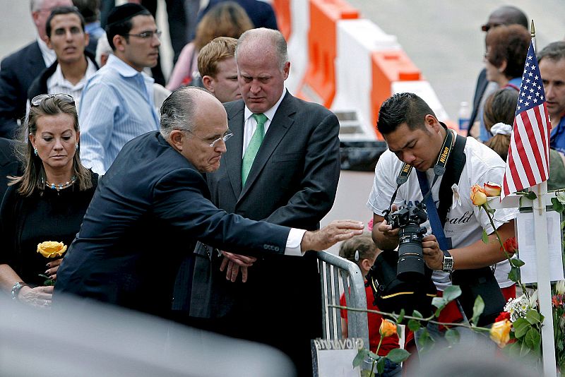 Rudolph Giuliani arroja flores en el estanque en memoria de las víctimas del 11-S