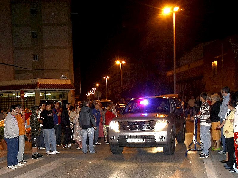 Un vehiculo de la policía atraviesa el cordón policial entre vecinos de Santoña, tras la explosión de un coche bomba ocurrido esta noche junto al Patronato Militar de esta localidad cántabra.