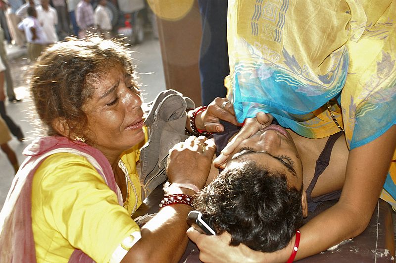 Una mujer llora ante el cadáver de su hijo