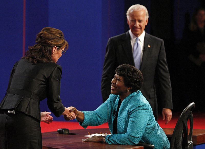 Palin saluda a la moderadora del debate, Gwen Ifill, ante la atenta mirada de Biden