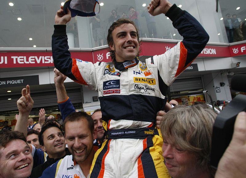 Alonso es llevado a hombros por sus compañeros mecánicos de la escudería Renault.