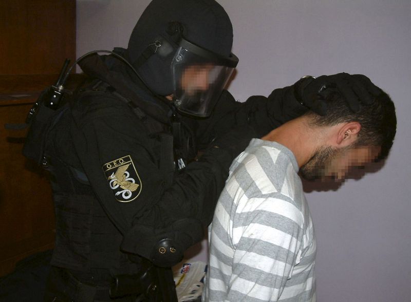 La Policía se lleva a uno de los ocho detenidos en la operación "Amat" contra el terrorismo islamista desarrollada esta madrugada en Barcelona, Madrid y Algeciras (Cádiz), y que formaban parte de una célula que daba cobertura y apoyo a terroristas de