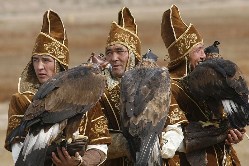 Kazakh hunters and their golden eagles wait for the start of the Kyrgyz hunting competition in Bokonbayevo