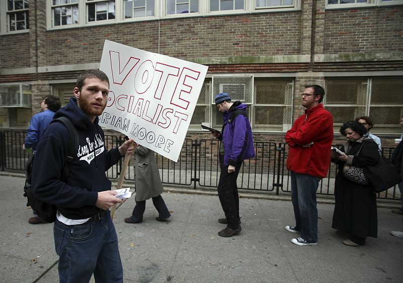 Un joven pide el voto socialista ante una cola de votantes en Brooklyn.