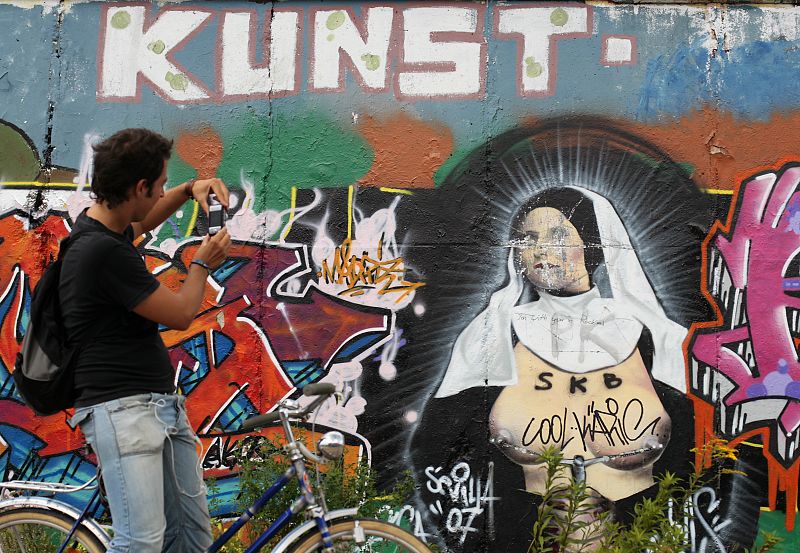 Un turista fotografía una pintada en la 'East Side Gallery'