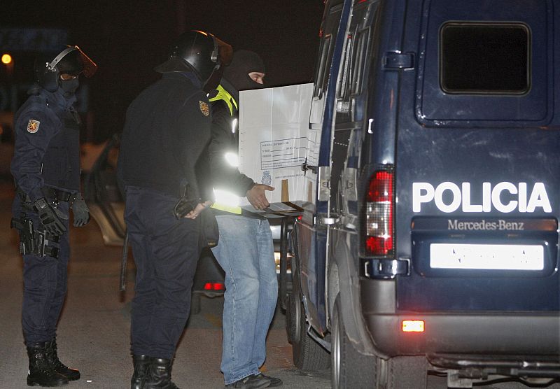 La Policía traslada varias cajas a un furgón durante el registro que realizaron en la asociación de vecinos del barrio de La Milagrosa en Pamplona, tras la detención de tres personas.