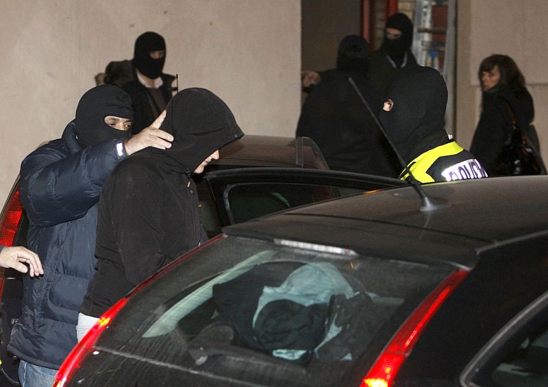 Efectivos del Cuerpo Nacional de la Policía trasladan a una de las tres personas que han sido detenidas esta madrugada en Pamplona, vinculadas con la organización ilegal Segi, en una operación ordenada por el juez de la Audiencia Nacional Fernando Gr
