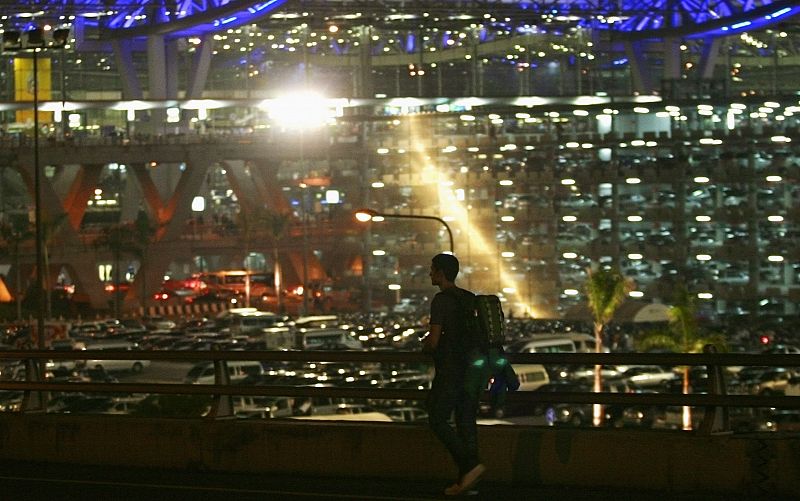 A tourist walks to Bangkok's Suvarnabhumi international airport after anti-government protesters blocked the main road