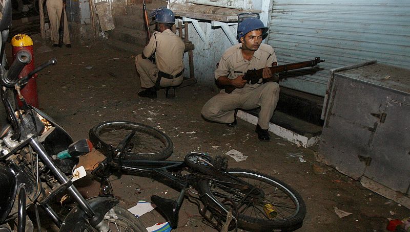 Police take up position at a blast site in Mumbai