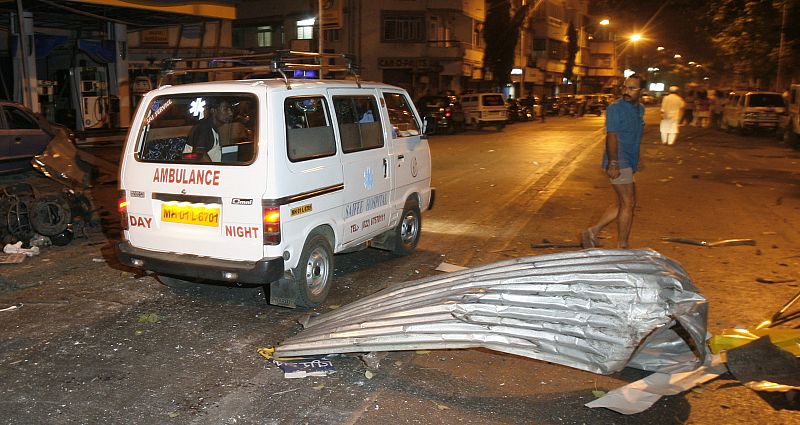 An ambulance makes its way through a blast site in Mumbai