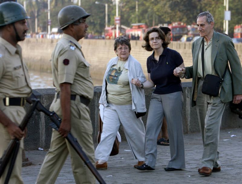 An employee of the Taj Hotel comforts foreign guests in Mumbai