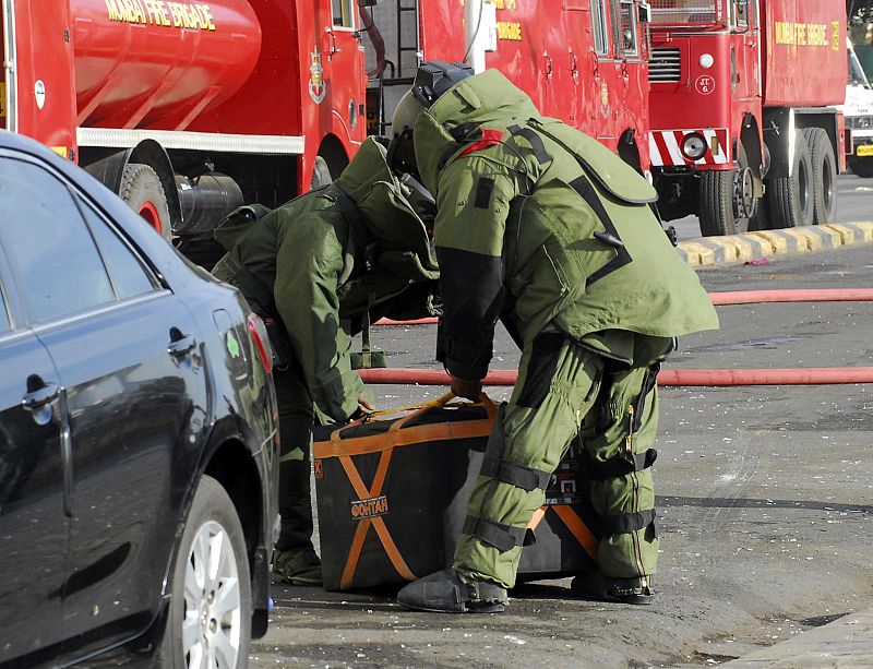 Miembros de la Guardia de Seguridad Nacional levantan un equipo preparado para desactivar bombas, cerca del hotel Taj