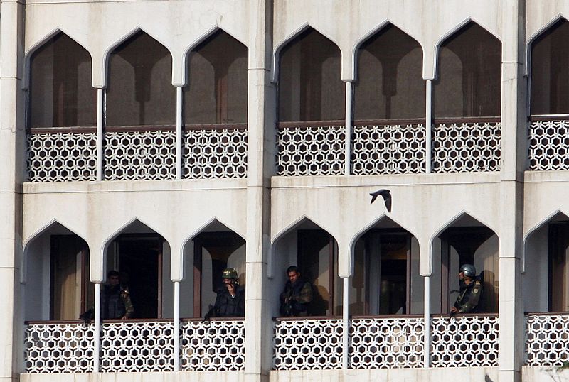 Un grupo de soldados vigilan desde uno de los balcones del hotel Taj