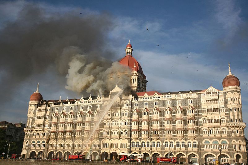 Los bomberos intentan apagar el fuego que consume el interior del hotel Taj