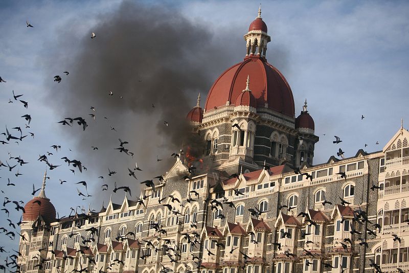 Una bandada de palomas vuela sobre el hotel Taj, incendiado tras los ataques