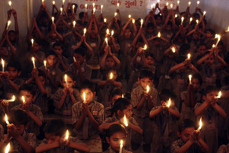 Unos alumnos sostienen velas durante la vigilia en Ahmedabad