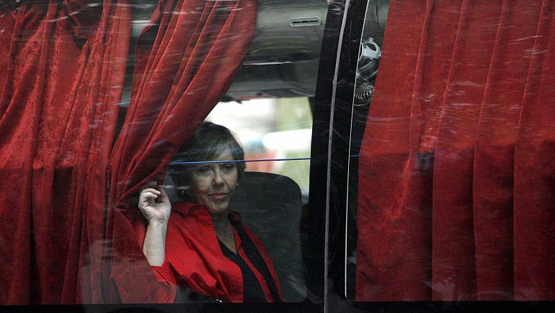 Una mujer mira a través de la ventana de un autobús despues de haber sido evacuada del hotel Oberoi