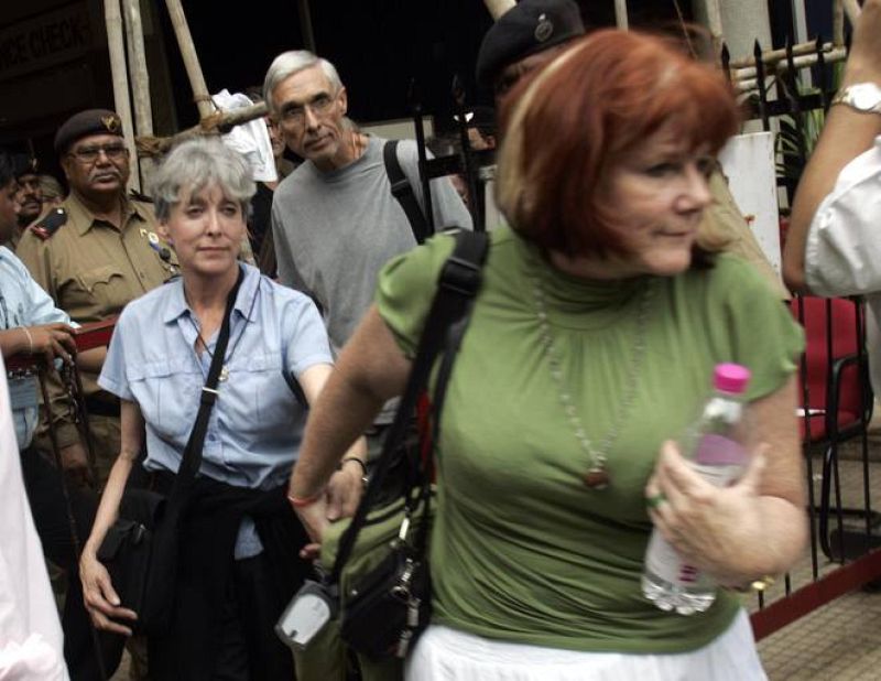 Un grupo de evacuados del Oberoi se dirige a un autobús 