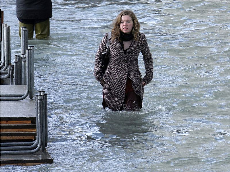 Una mujer camina por una calle inundada de Venecia