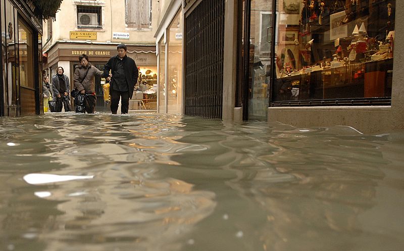 Los turistas se abren paso por las calles inundadas de Venecia