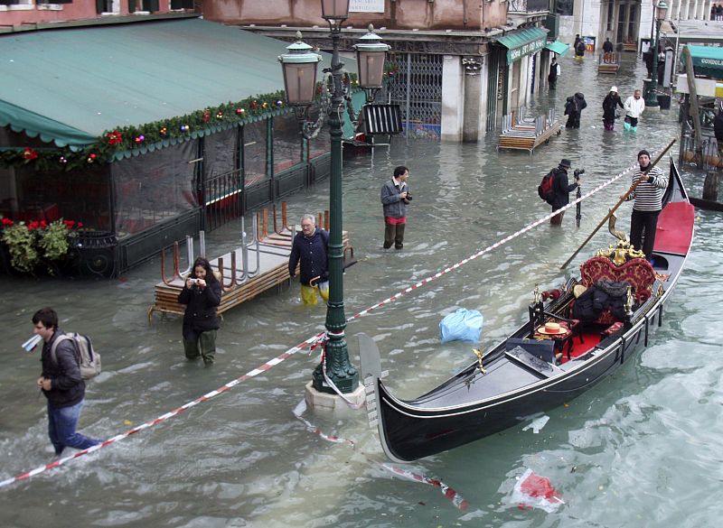 Los peatones caminan por las calles inundadas de Venecia