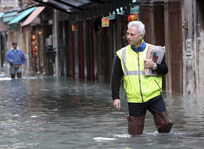 Un cartero lleva las cartas por las calles inundadas de Venecia