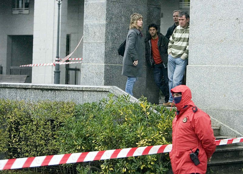 Varias personas esperan en las inmediaciones del lugar donde dos terroristas han disparado hoy al empresario Ignacio Uría.