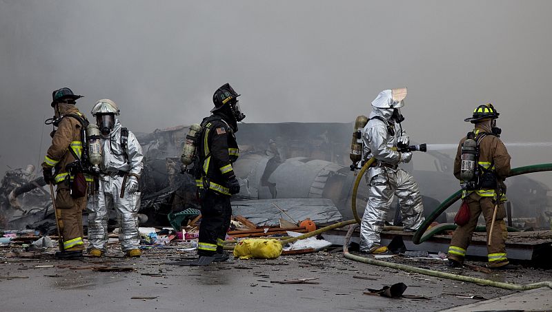 Los Bomberos apagan las llamas junto a los restos del F-18 y de las casas que ha destruido con el impacto (09/12/08).