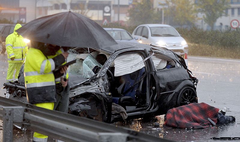 Agentes de la Guardia Civil toman notas en el lugar de la A-3, sentido Valencia, en el término de Quart de Poblet, donde se ha producido un accidente de tráfico en el que el conductor de un turismo ha muerto al quedar "aplastado" en el interior del v