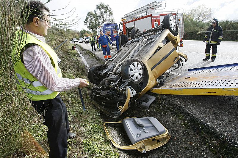 Bomberos y Guardia Civil asisten a la retirada de la carretera de Covelo del vehículo que conducía P.G.V. cuando sufrió el accidente que le costó la vida.