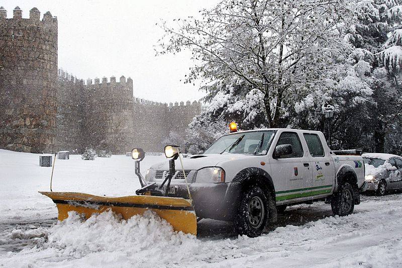 Una quitanieves en la tarea de limpieza de la vía ante la muralla de Avila después de una intensa nevada.