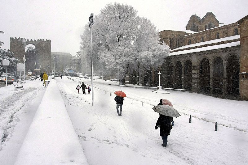 Imagen de una calle de Avila, tras la intensa nevada que ha cubierto hoy la ciudad, lo que crea problemas en la circulación y dificultades varias que han llevado al Ayuntamiento a aconsejar a la población que no salga de casa.