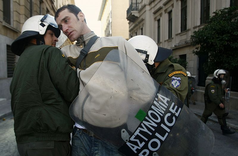 Uno de los manifestantes es detenido por dos agentes de policía.