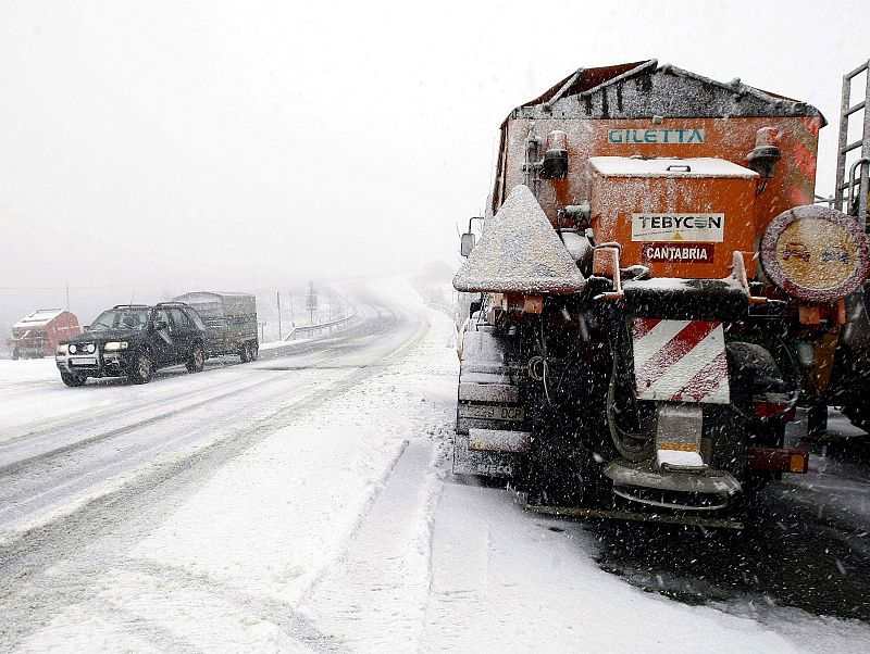 Un vehículo circula por la N-623 a la altura del puerto de El Escudo en medio de una de las intensas nevadas que están cayendo en las zonas interiores de la cornisa cantábrica.